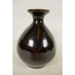 A Japanese treacle glazed pottery wine flask of bulbous form with character inscription to base, 6¼"