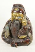 A Chinese gilt and red bronze figure of a bearded Lohan with small child in his arm, 9" high