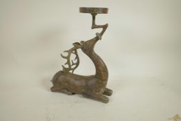 An archaic style Chinese bronze figure of a deer supporting a candle/bowl stand, 13" high