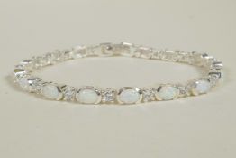 A silver bracelet set with alternating cubic zirconium and opalite, 7" long