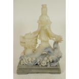 A Chinese carved soapstone figure of Guan Yin on the back of a dragon, 11" high