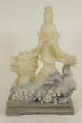 A Chinese carved soapstone figure of Guan Yin on the back of a dragon, 11" high