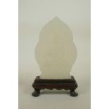 A Chinese white hardstone ornament in a hardwood stand with carved Buddha decoration, 6½" high