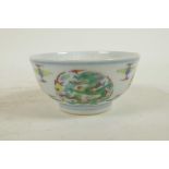 A Chinese carved doucai porcelain rice bowl with enamelled dragon decoration, 6 character mark to