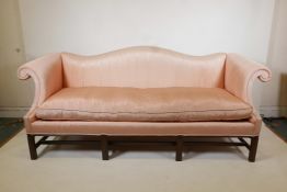 A pair of American vintage camel back settees with pink silk upholstery on fluted square supports,