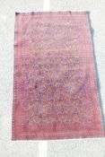 A Middle Eastern rug decorated with a floral medallion design on a blue field, with a brown and