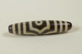 A Tibetan agate Dzi bead, 2" long