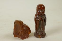 A Chinese carved horn figure of Buddha, together with an amber shard, 3" high