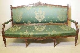 A late C19th/early C20th Italian walnut showframe, open arm settee, with carved crest and finials
