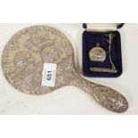 An embossed silver cherub hand mirror together with a silver perfume flask and funnel, and a