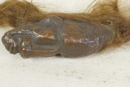 A tribal ceremonial bronze head with attached hair, 5" long