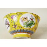 A Chinese porcelain yellow ground bowl decorated with floral swags and panels of birds and