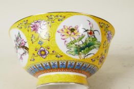 A Chinese porcelain yellow ground bowl decorated with floral swags and panels of birds and