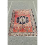A Persian washed red ground Afshar rug, 65" x 24"