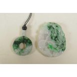 A Chinese carved mottled green jade pendant with carp and lotus flower decoration, and another green