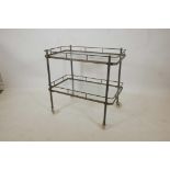 A brass and glass two tier hostess/drinks trolley in the Art Deco style, 28½" high, 29½" x 17½"