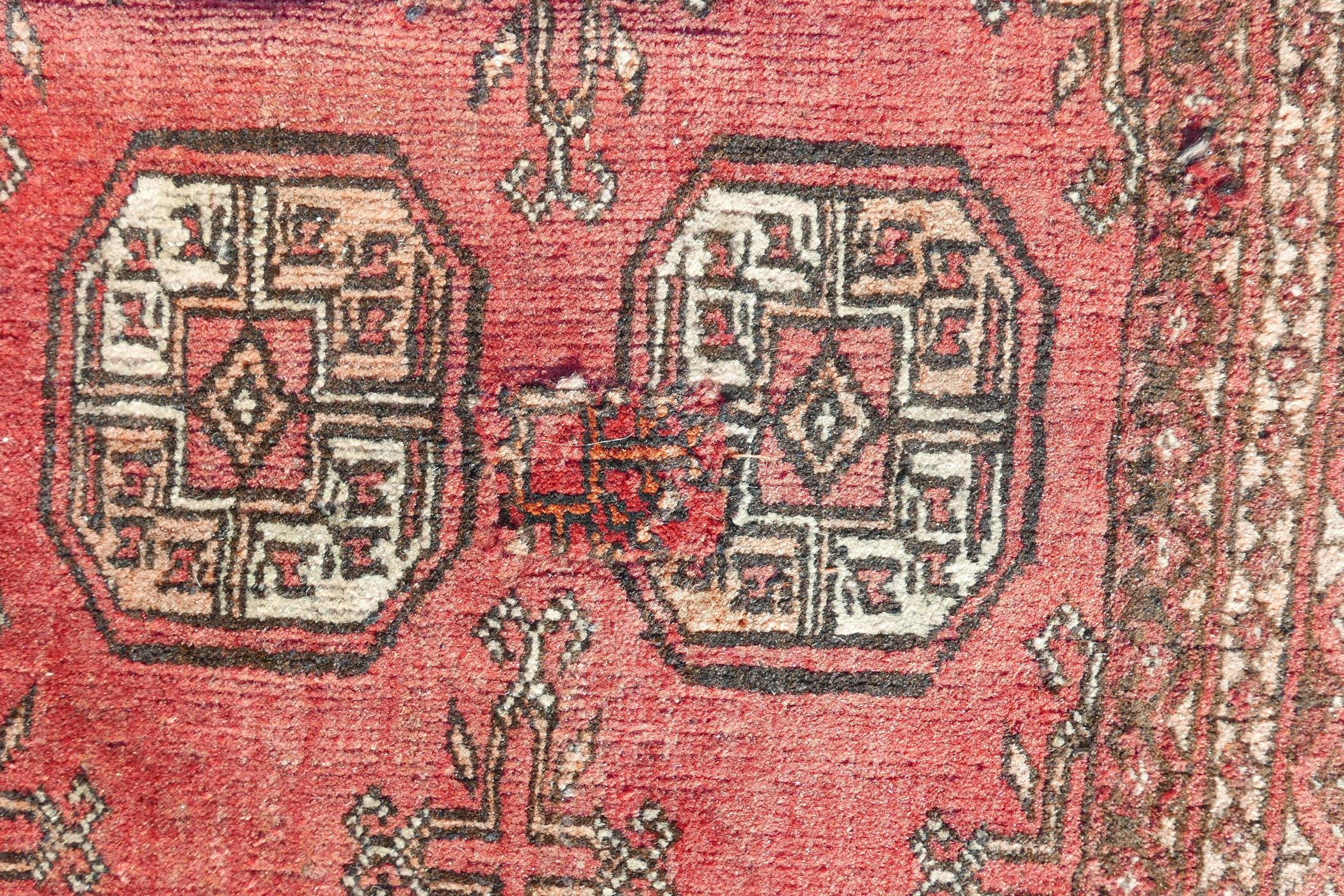 A washed red ground Turkmen carpet with a Bokhara design, repairs, 56" x 90" - Image 2 of 6