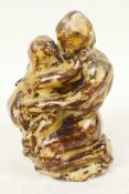 A small treacle glazed studio pottery figure of a mother and child embracing, 3½" high