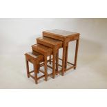 A nest of four Chinese limed teak occasional tables, with carved tops under inset glass, 20" x 14" x