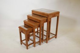 A nest of four Chinese limed teak occasional tables, with carved tops under inset glass, 20" x 14" x