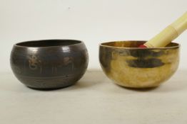A Tibetan gilt bronze singing bowl, and another with character script decoration to exterior and