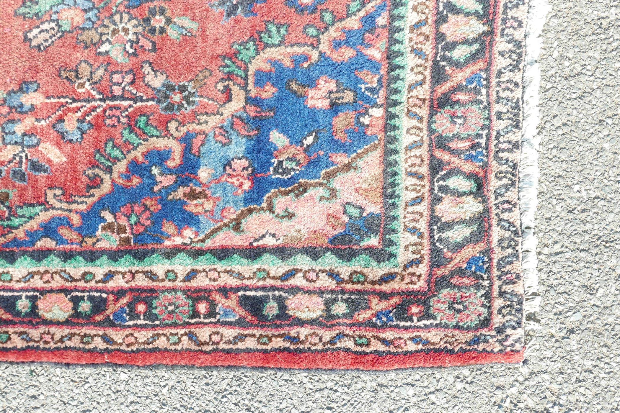 A full pile Sarouk runner with a traditional design on a red ground, 46" x 123" - Image 3 of 4