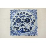 A Chinese blue and white porcelain temple tile, with floral decoration, 8" x 8"