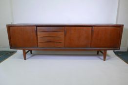 A Danish 1960s teak sideboard designed by Gunni Omann fo Axel Christiansen, with three sliding doors