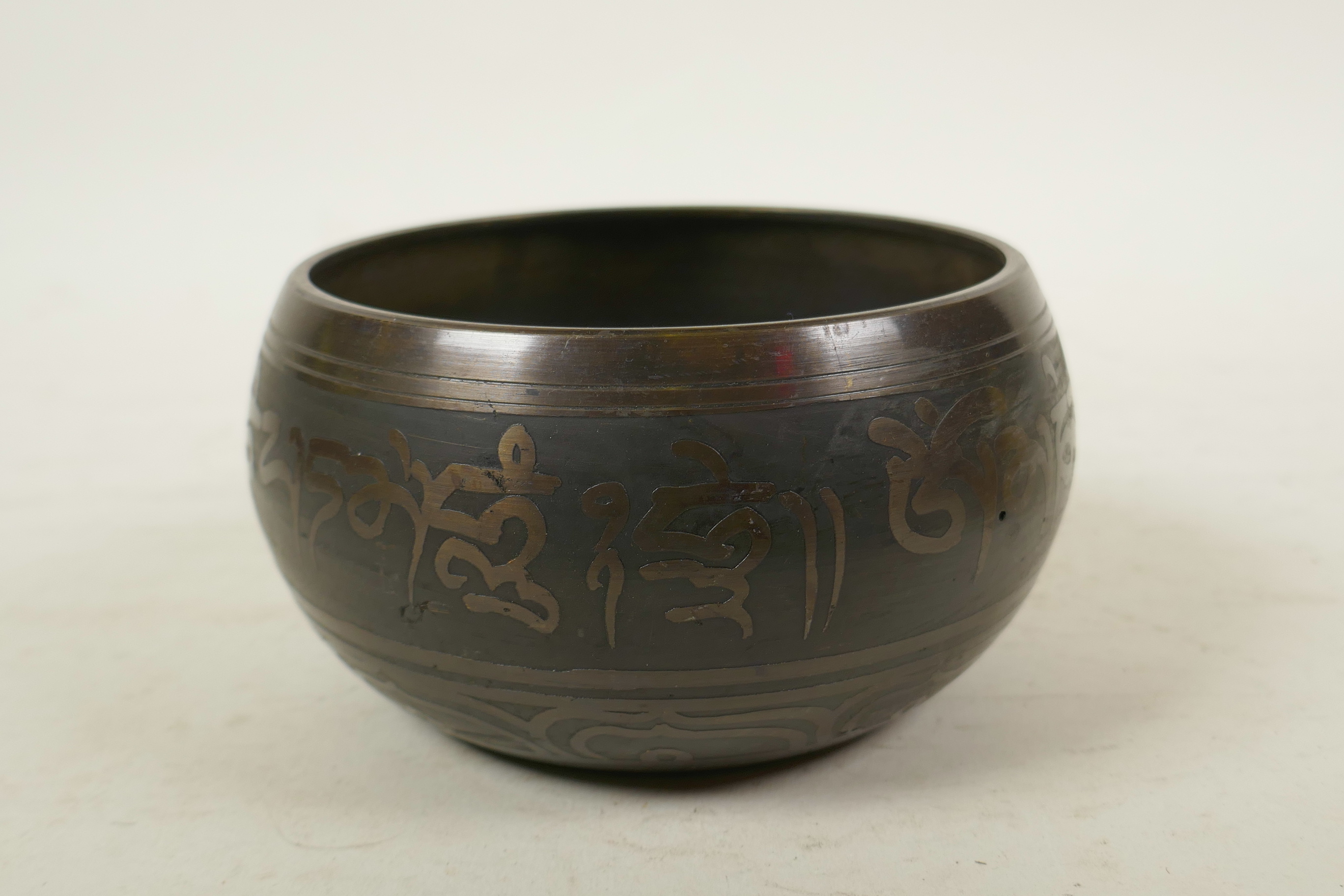 A Tibetan gilt bronze singing bowl, and another with character script decoration to exterior and - Image 5 of 7