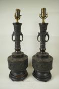 A pair of Japanese bronze table lamps in the form of long necked cylindrical vases with elephant