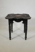 A Chinese shaped top table, carved with dragons and chinese characters, raised on carved and