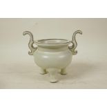 A Chinese Song style cream glazed porcelain censer with two handles, raised on tripod feet, seal