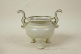 A Chinese Song style cream glazed porcelain censer with two handles, raised on tripod feet, seal