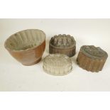 A stoneware jelly mould, 6" high, together with two copper moulds and a moulded glass example