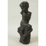 A bronze figure of a stylised boy seated on a rock, 10½" high