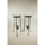A pair of blown glass hurricane vases on wrought iron tripod stands, 16½" high, A/F chips to rim