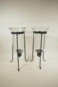A pair of blown glass hurricane vases on wrought iron tripod stands, 16½" high, A/F chips to rim