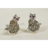 A pair of silver and marcasite cufflinks in the form of cats with ruby eyes