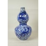 A Chinese Ming style blue and white porcelain double gourd vase decorated with carp in a lotus pond,