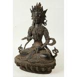 A Chinese bronze figure of Buddha seated in meditation holding a vajra and bell on a lotus throne