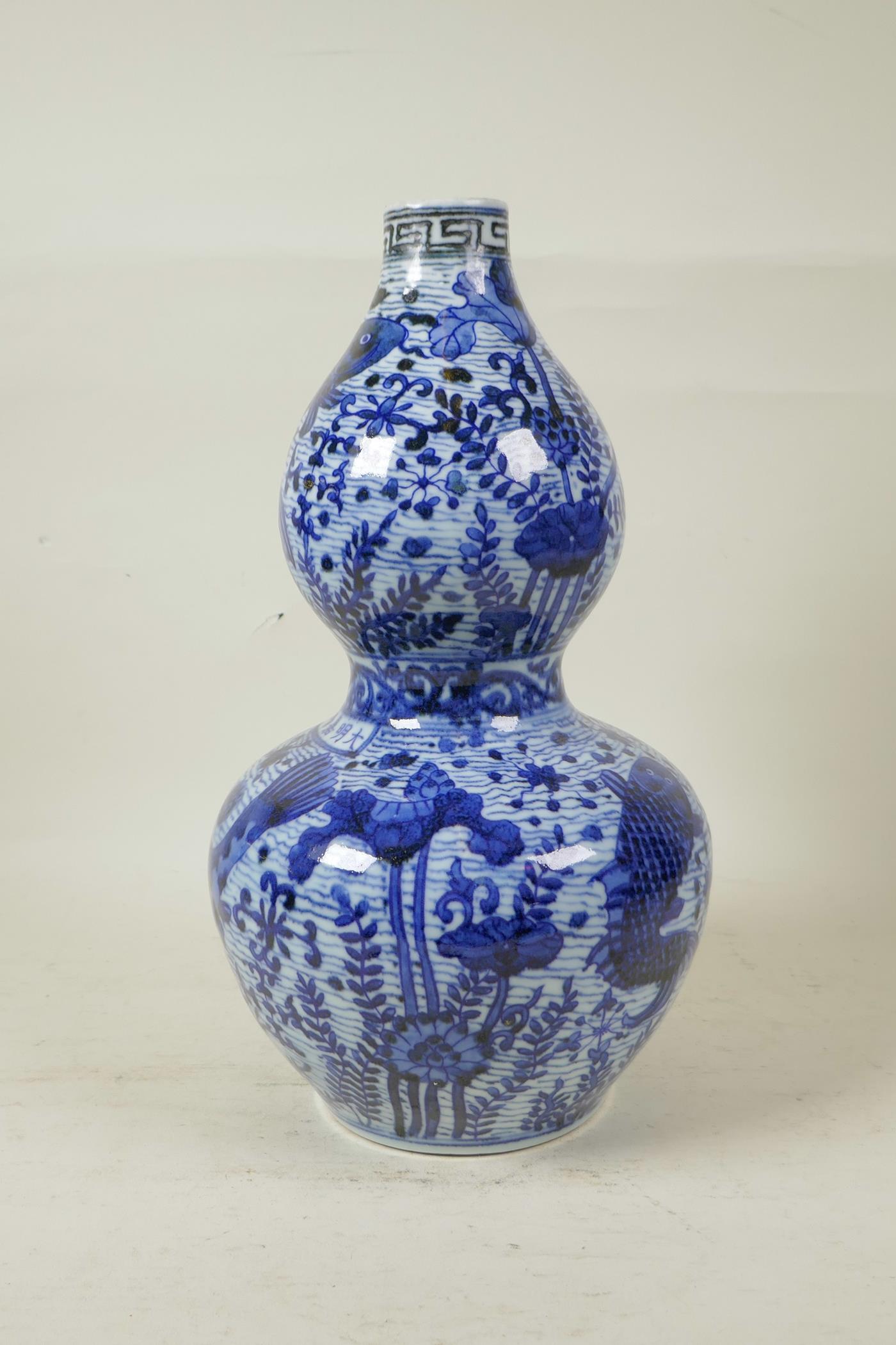 A Chinese Ming style blue and white porcelain double gourd vase decorated with carp in a lotus pond, - Image 2 of 6