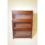 An oak three tier Globe Wernick style bookcase by Gunn Furniture Co of Michigan, with a stepped