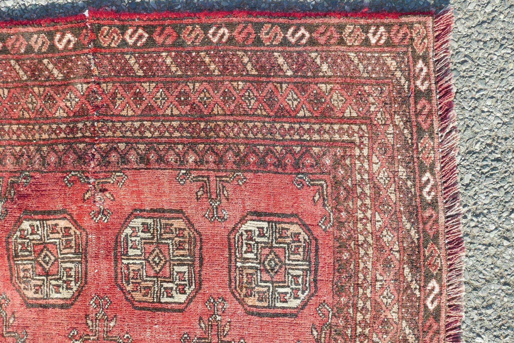 A washed red ground Turkmen carpet with a Bokhara design, repairs, 56" x 90" - Image 5 of 6