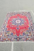 A multicoloured ground Iranian carpet from the Tabriz region decorated with a floral pattern on a