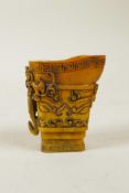 A Chinese carved horn libation cup with kylin decoration, 2½" high
