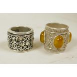 A Chinese white metal archer's thumb ring with a revolving cuff decorated with bats and symbols, and