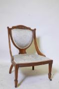 A Victorian walnut Grecian style parlour chair, with carved crest and shield shaped splat back,