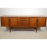 A mid century G-Plan teak 'Fresco' sideboard with a bank of four drawers flanked by cupboards,