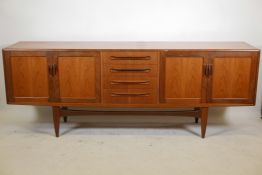 A mid century G-Plan teak 'Fresco' sideboard with a bank of four drawers flanked by cupboards,