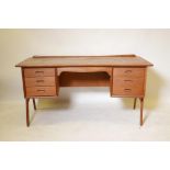 A Danish mid century teak, two sided desk designed by 'Svend and Madsen' for Sigurd Hansen, 59" x